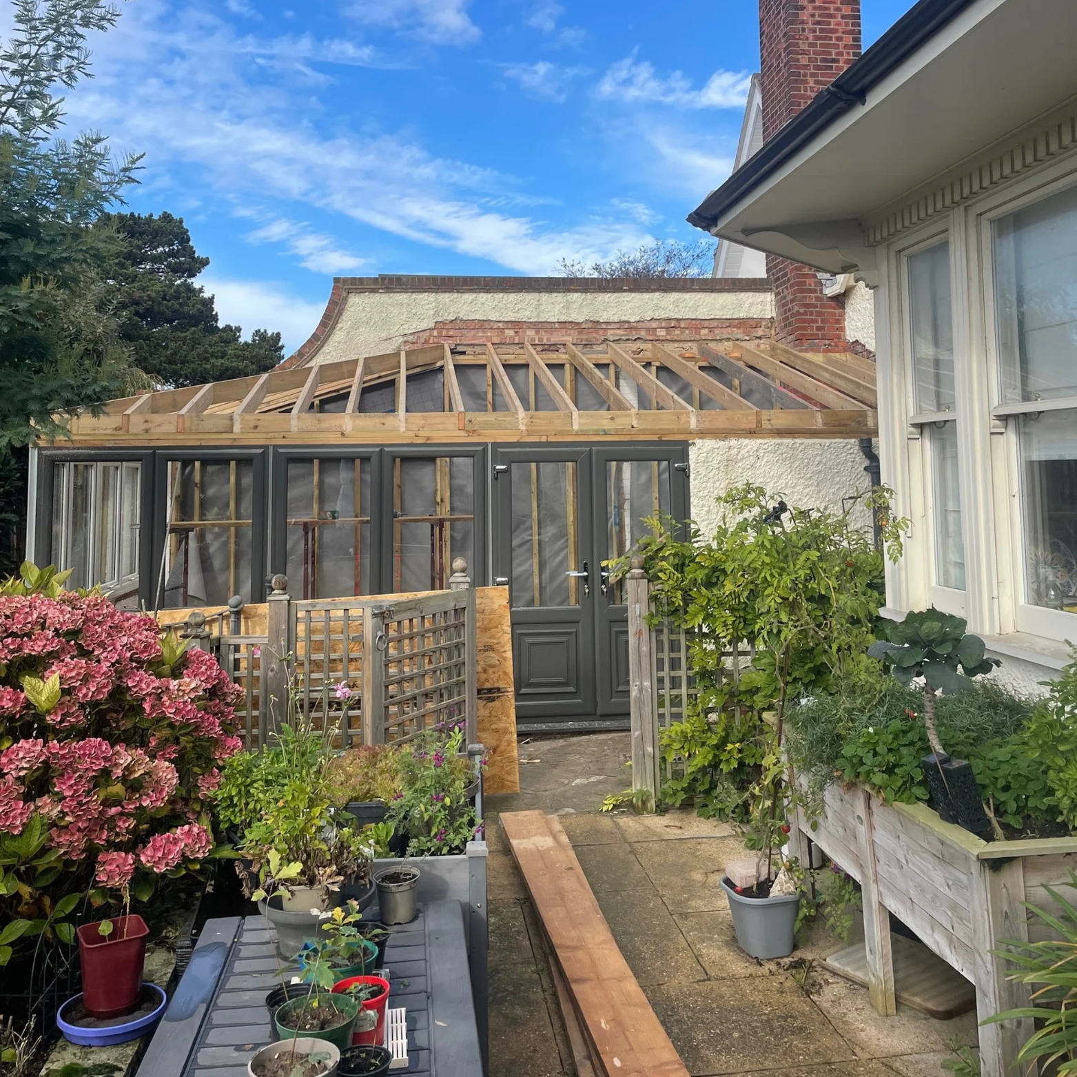 Timber garden room with glass roof and rustic wooden frame built by DT Carpentry Kent.